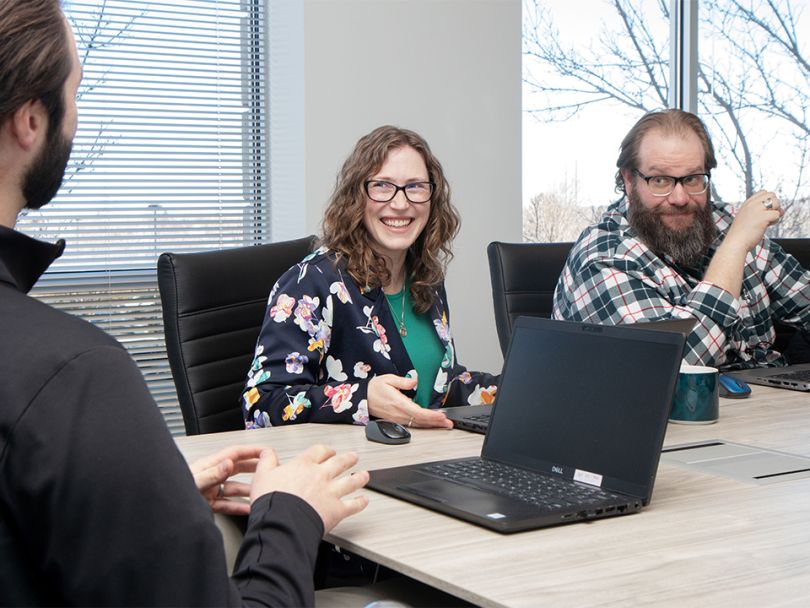 KPA employees laugh together during a team meeting.