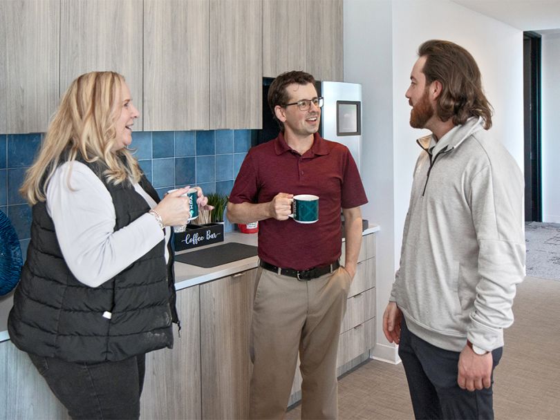 A group of KPA employees chat over coffee.