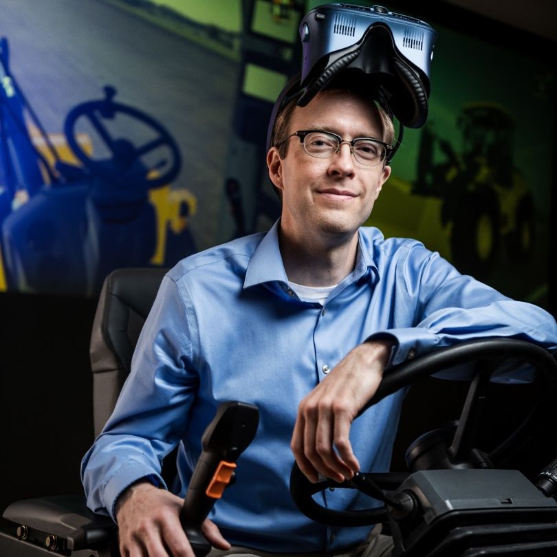 Portrait of Kurt Chipperfield sitting at the wheel of a piece of John Deere equipment.