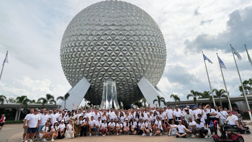 Kustomer team members pose for a large group photo at Epcot in Disney World during a company offsite