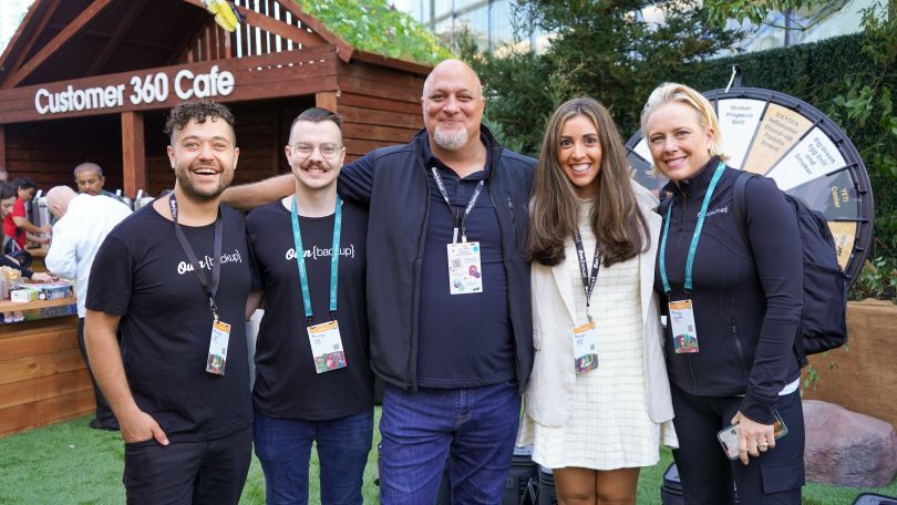 Group photo of five OwnBackup team members outside near a place called “Customer 360 Cafe.