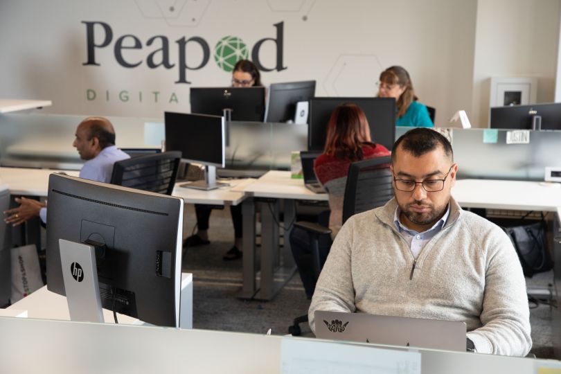 Peapod Digital Labs team members working in open office space.