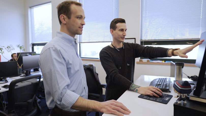 LightForce employees collaborate in front of a computer screen