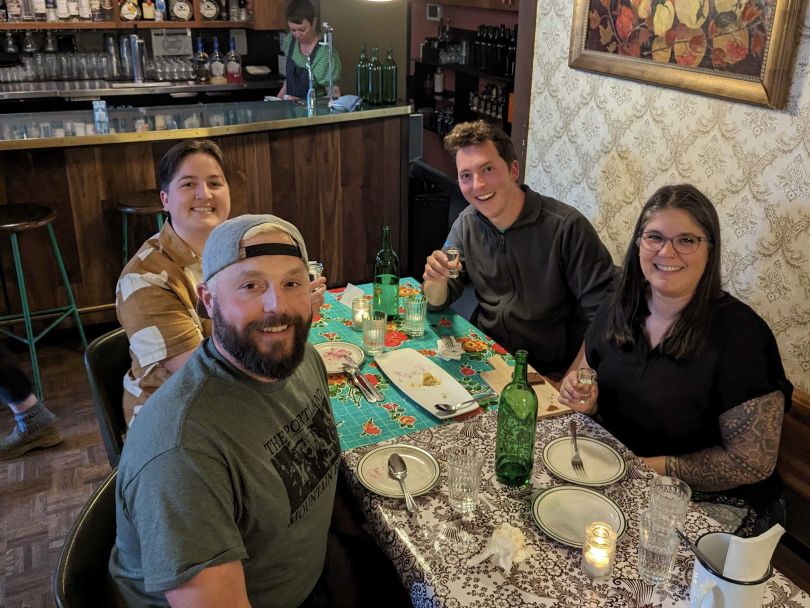 Four Portland-based Lob team members sitting around a table with food and wine.