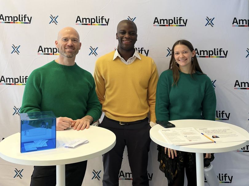 Three members of MarketAxess’ ERG, Amplify, standing in front of a white backdrop. 