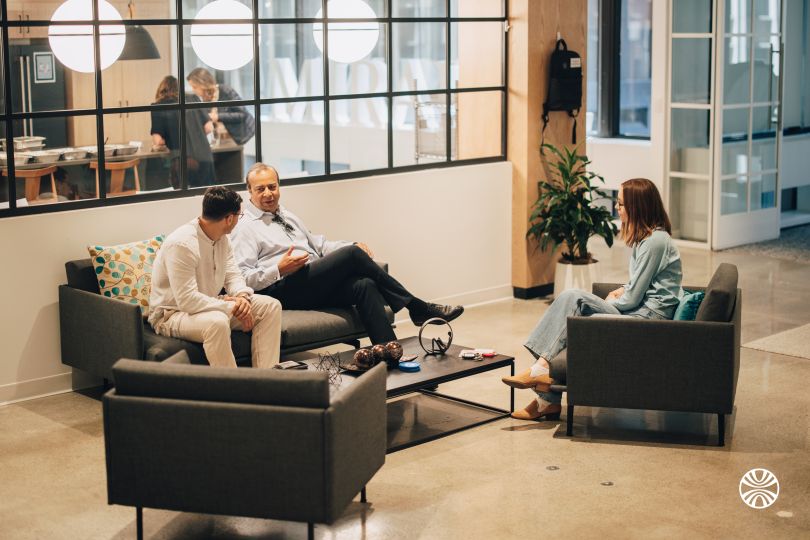 Three Mirakl team members chatting while seated in a lounge space in the company’s office