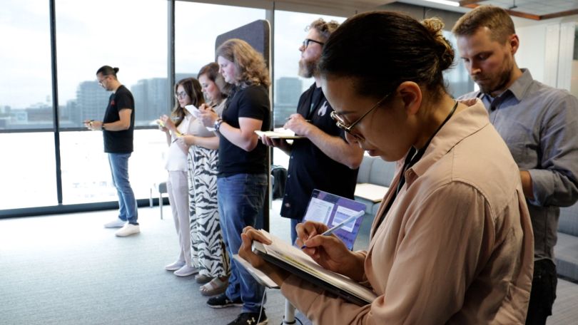 Group of people standing taking notes