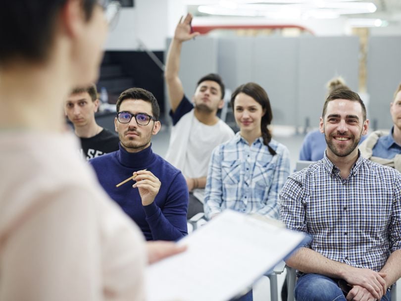 One employee raises his hand during a company group training session.