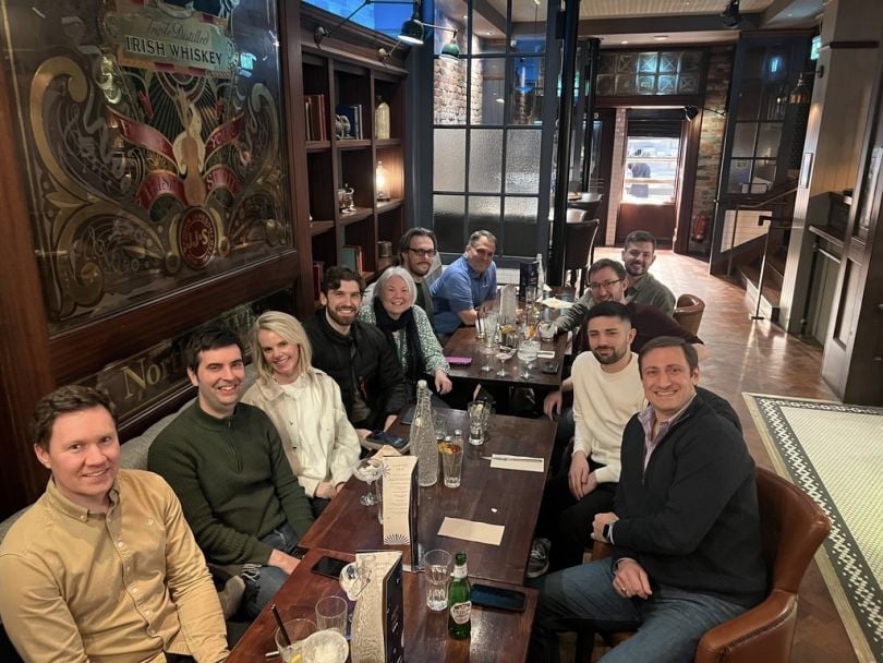 CEO LaSalle and other Nisos employees smile for a photo while out for drinks at a Belfast pub.