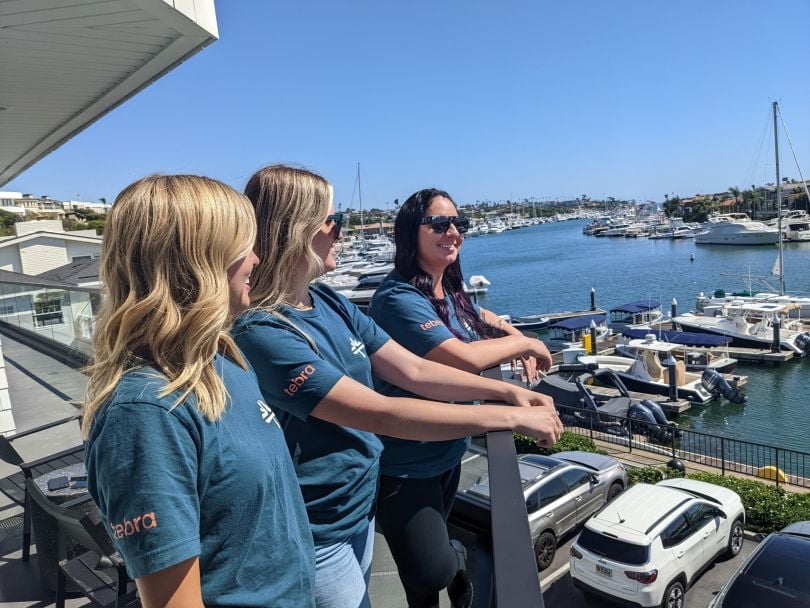 Tebra team members in branded t-shirts along a pier