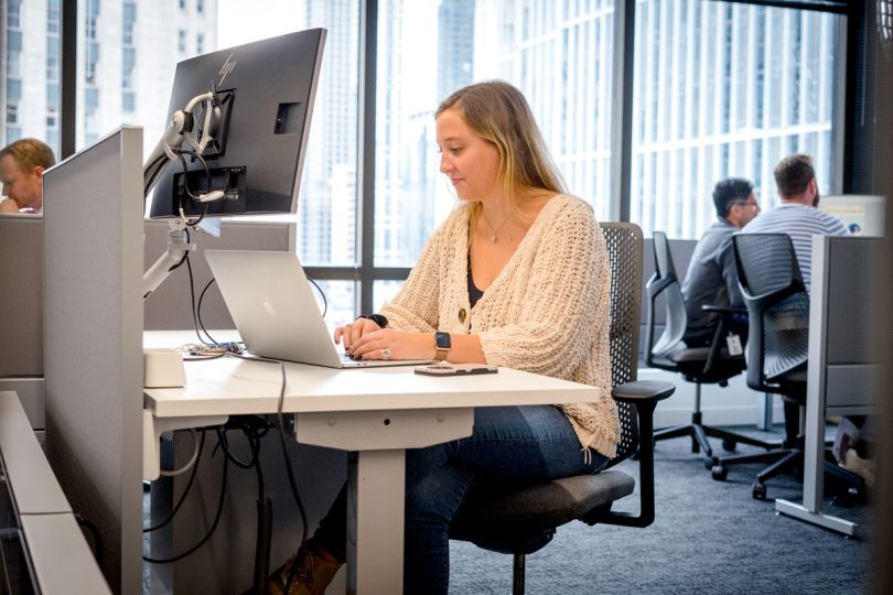 Pareto Intelligence team member sitting at a desk in the office working on a laptop