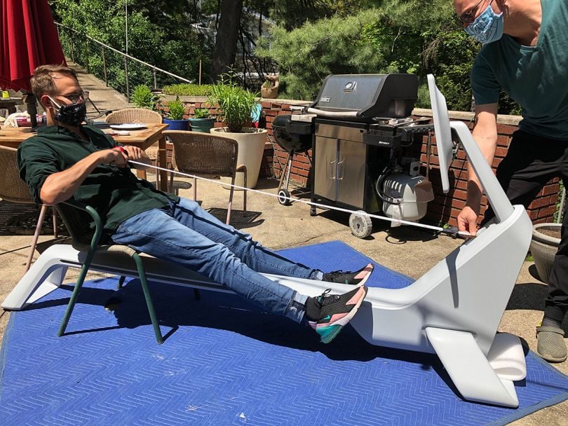 A user testing the Row machine outside in a mask. 