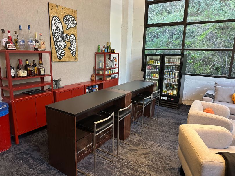 A table situated next to a fridge filled with beverages in Philo’s office