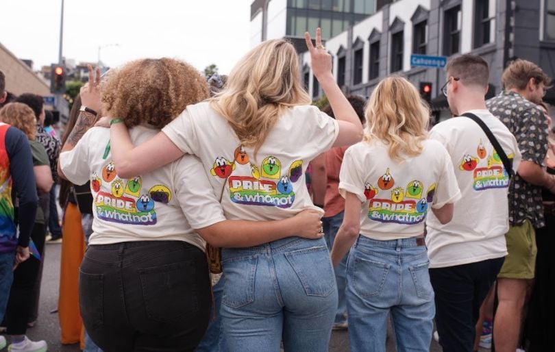 Four Whatnot team members face away from camera, wearing Whatnot-branded Pride T-shirts