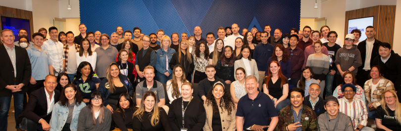 Prime Trust employees stand indoors as a group