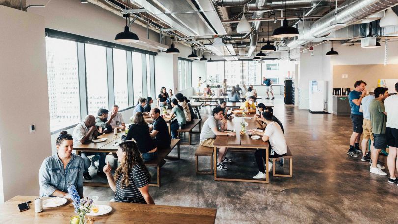 People eating lunch in the kitchen and dining area inside Qualtrics’ office.