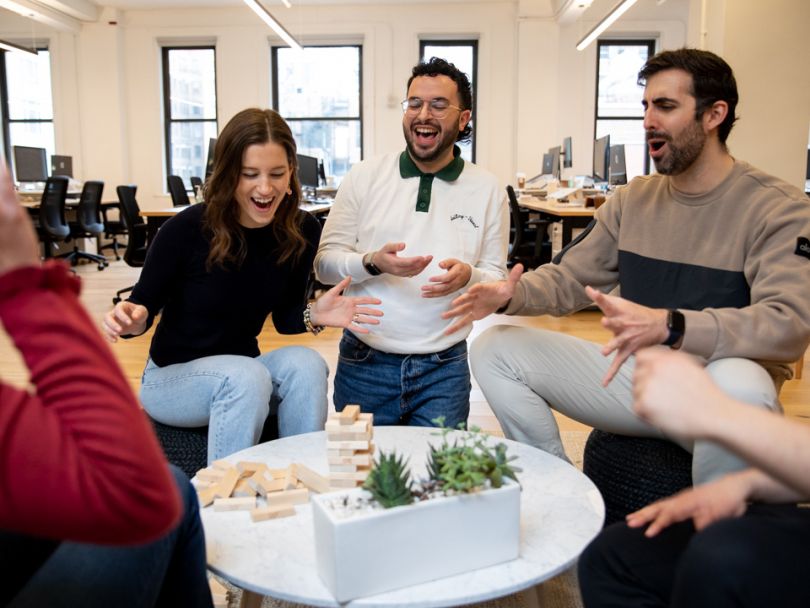 Reonomy team members bonding over a game of Jenga at the office