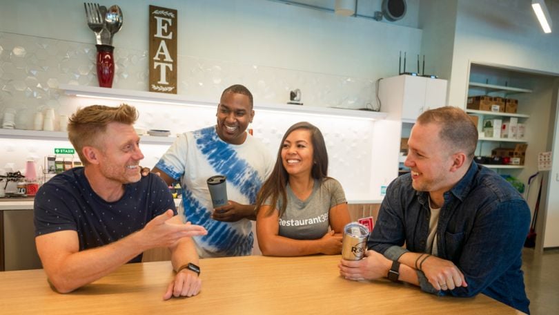 Restaurant365 coworkers having a team huddle int he office kitchen