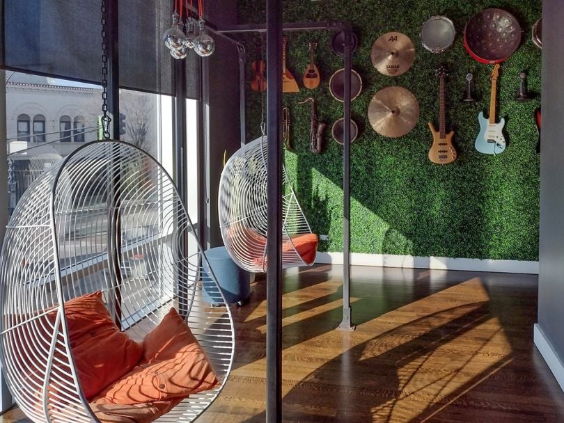 Room in the Reverb office with guitars on the wall and sing chairs