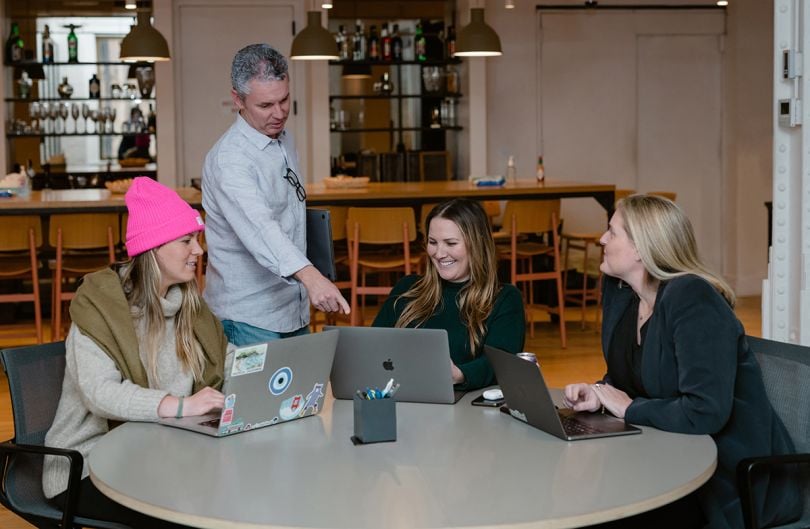 Riskified coworkers sitting around a table having a team huddle