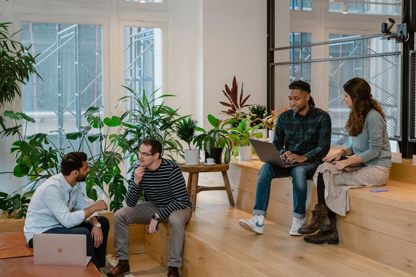 Riskified team members collaborating sitting on bleacher style seating in the office