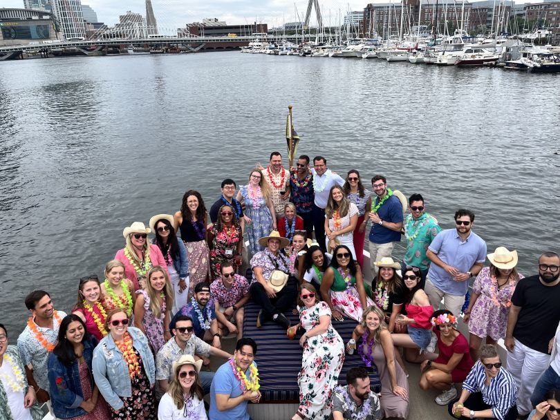 The SOPHiA GENETICS team poses for a large group photo on the bow of a ship.