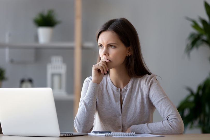 An anxious woman looking at a laptop