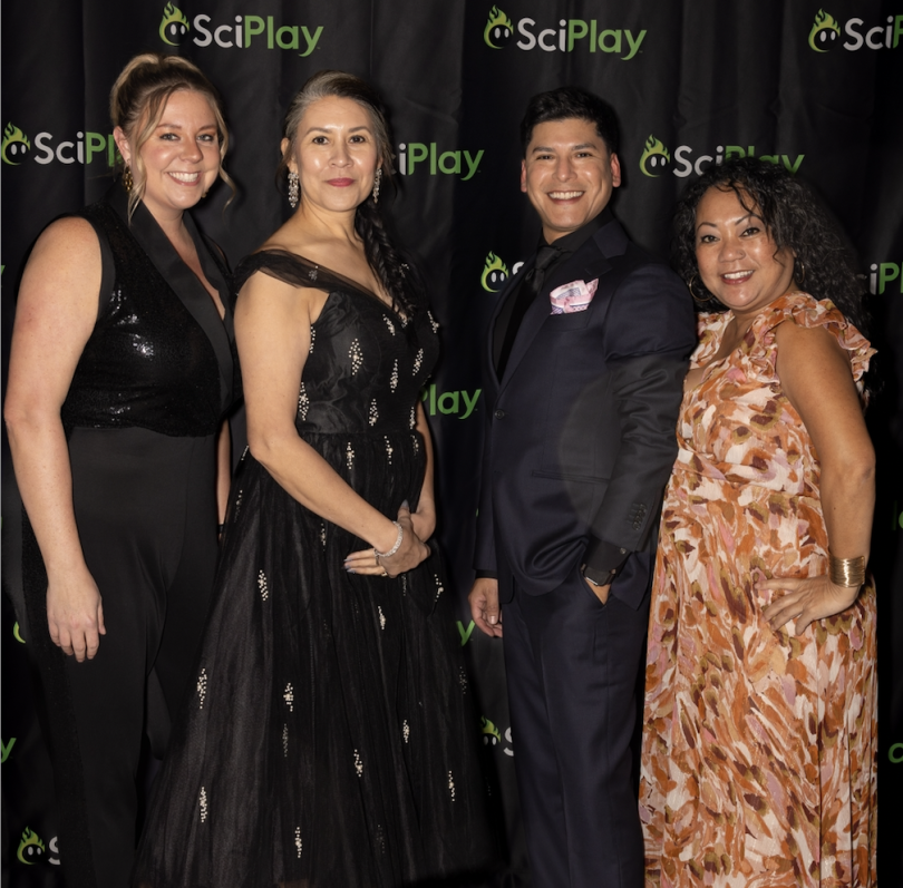 Micayla Evers and Rozlyn Ramirez pose for a photo with a couple of coworkers during a formal company event