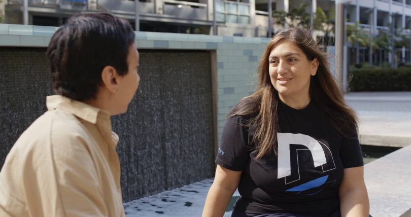 Marcela Fernandez Reed and another DIRECTV employee chatting outside of the office