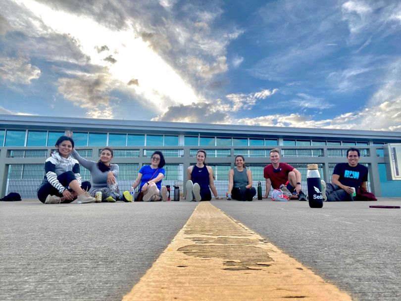 Employees from Sedera sit outside together while wearing athletic clothing