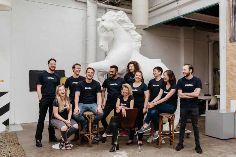 The Sendle team pose in front of a large plaster equestrian statue