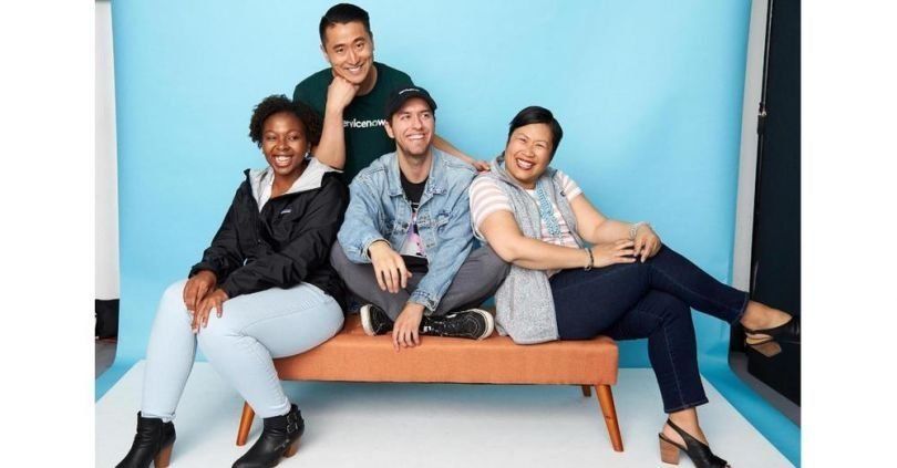 A group of ServiceNow employees pose in the office.