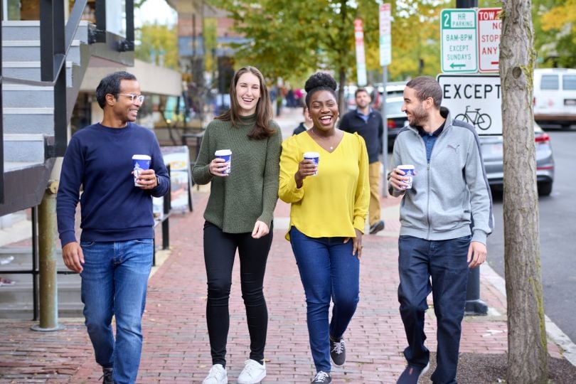 Kensho employees walk through Cambridge, MA, with coffees