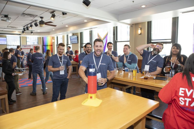 Photo of Bringg team members gathering, wearing the same T-shirt and lanyards, one team member smiling and shouting toward camera.