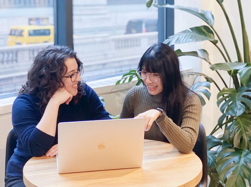 Two Summer team members having a conversation looking at a laptop