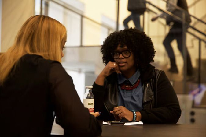 Two employees chat over lunch.