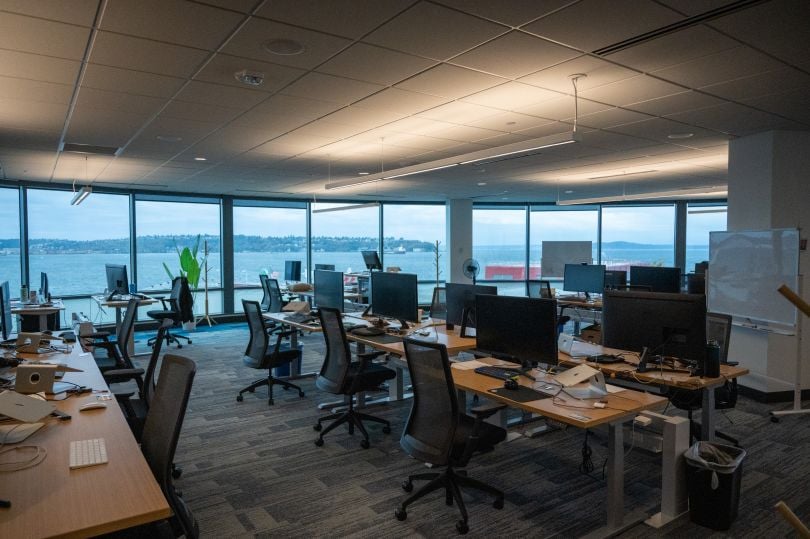 Rows of desks in the TaxBit office look out at the water through a wall of windows.