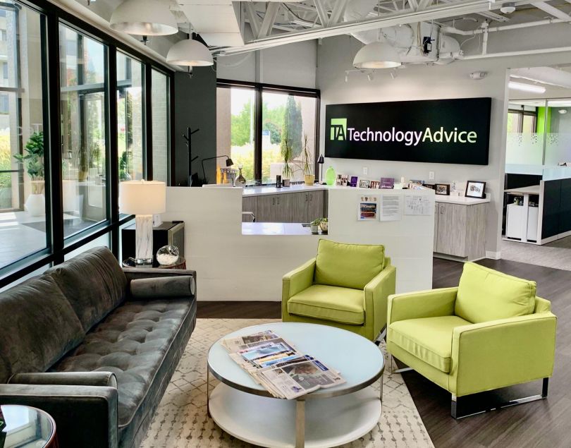 TechnologyAdvice's office, which features big windows, a gray couch and two yellow-green chairs