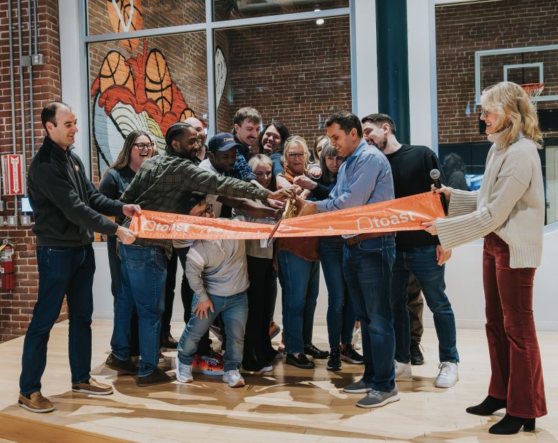 Toast employees cut the ceremonial ribbon at the grand opening of their Boston office.