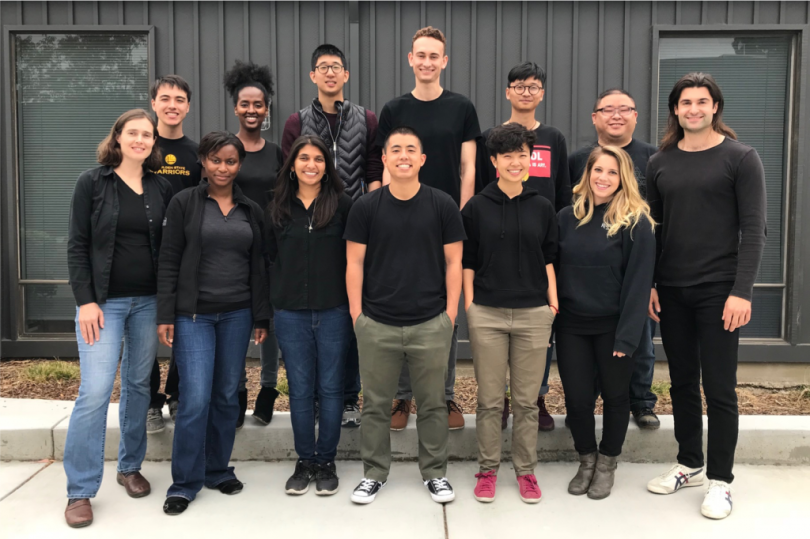 A group of employees from Twelve stand in two rows together, and they are all wearing dark shirts