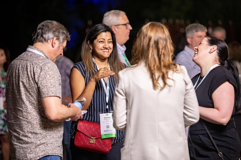 Unanet team member having a conversation with colleagues at a conference