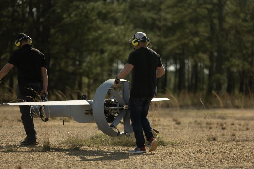 Two men move a drone at a VBAT test flight at Fort Benning