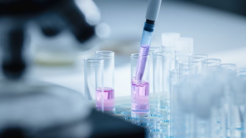 Close Up Shot of a Scientist Using Micro Pipette and Mixing Chemical Liquid with Genetically Modified Samples Under a Microscope