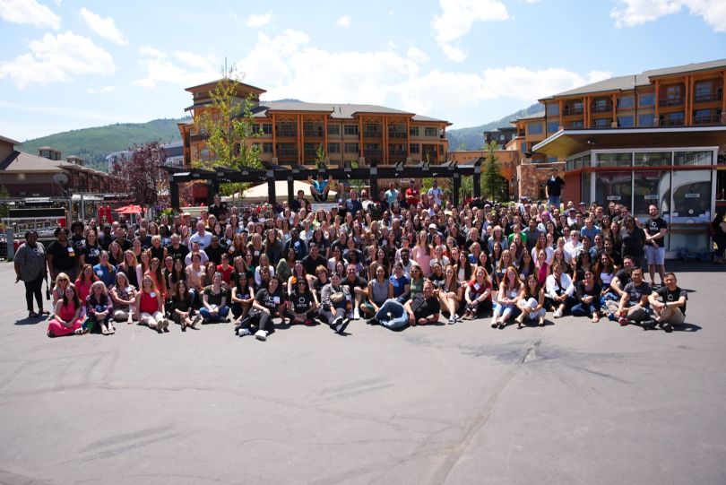 Virta employees stand outside on a sunny day in front of buildings