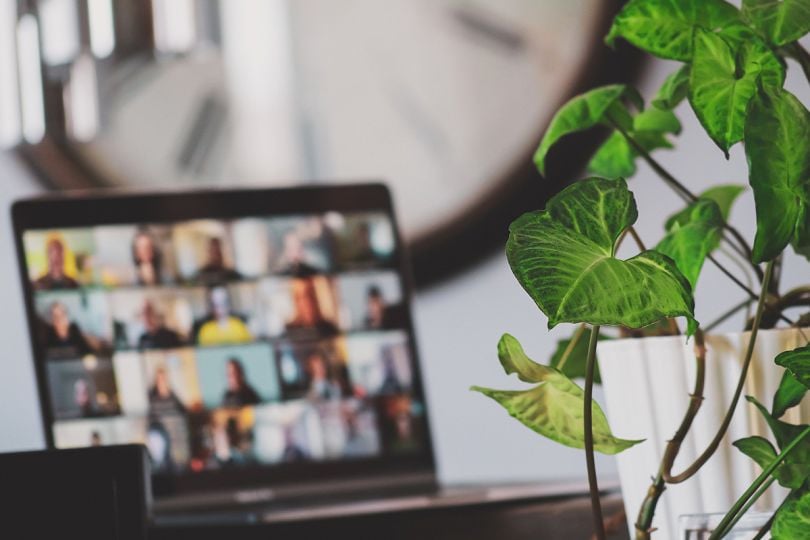 A laptop in a team member's home with colleagues on a video call