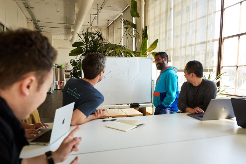 whiteboard session with six employees and someone in front