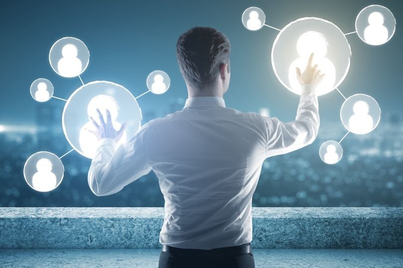  A man interacting with a futuristic interface of workforce profiles against a city skyline.