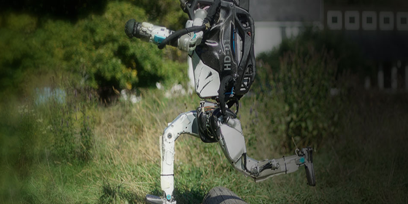 The humanoid robot, Atlas, running through a field.