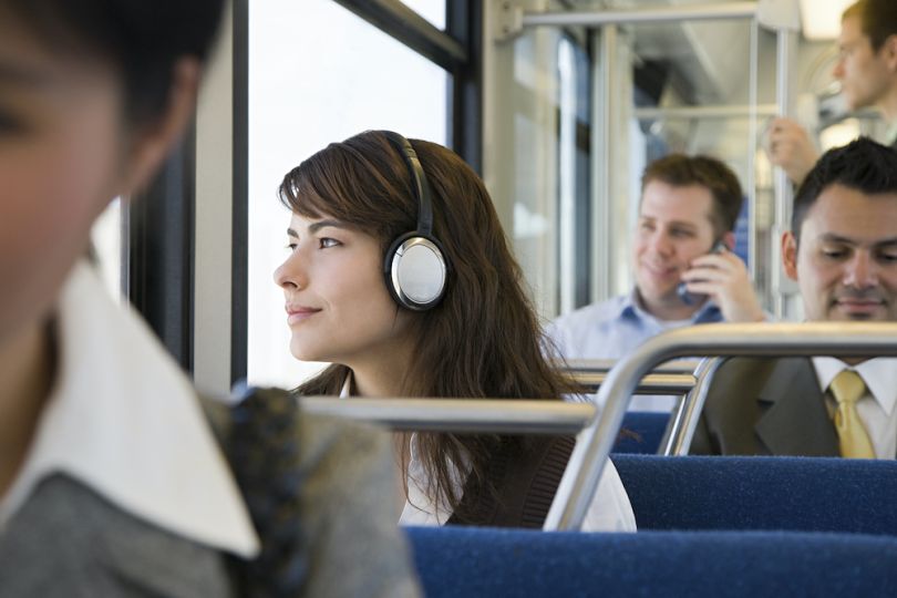 Audible employee on a bus wearing headphones