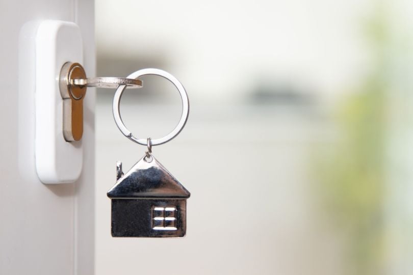 A key in a lock with a house-shaped keychain.